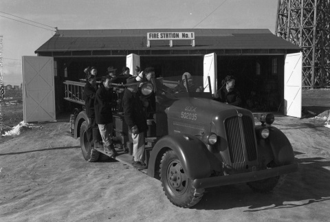 Firemen on a fire truck at Fire Station No. 1 (ddr-fom-1-773)