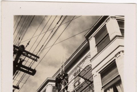 Two men standing on fire escape (ddr-densho-426-21)