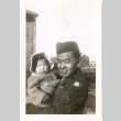 Man in uniform holding baby (ddr-densho-430-173)