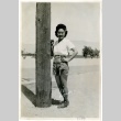 Woman standing next to a telephone pole (ddr-manz-6-23)