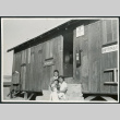 Photograph of two women an a young child posing in front of the infirmary at Cow Creek Camp in Death Valley (ddr-csujad-47-136)