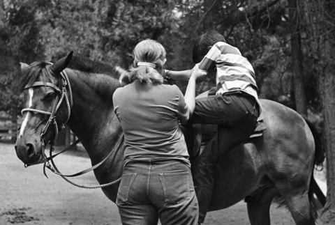 Brad Shirakawa helped onto a horse (ddr-densho-336-236)