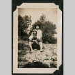 Walter Matsuoka and a woman sit on a rocky bank (ddr-densho-390-96)