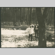 Black and white photos of groom carrying bride in snowy woods (ddr-densho-523-385)
