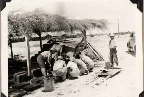 Group working under thatch shelter (ddr-densho-587-90)