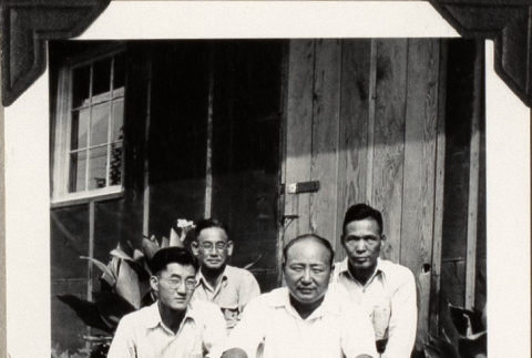 Four men sitting outside barracks (ddr-densho-587-25)