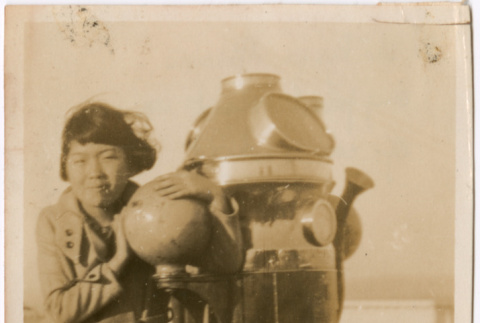 Girl standing next to machine on boat (ddr-densho-423-558)
