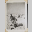 Man pulling on shorts on beach (ddr-densho-466-858)