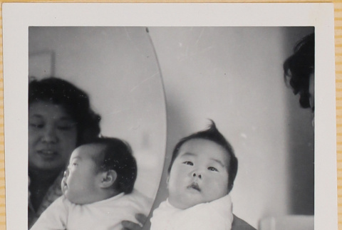 Yoshiko Shiomi holding Leslie Shiomi with mirror reflection (ddr-densho-522-347)
