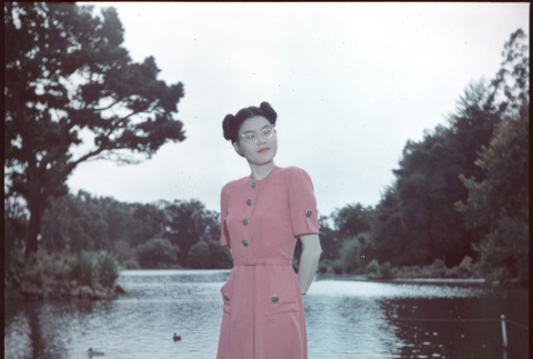 Woman in pink dress standing by pond (ddr-densho-426-937)
