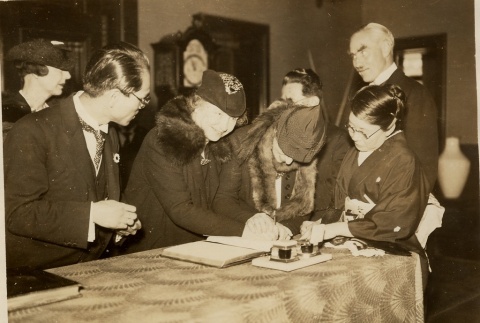 Helen Keller signing a book on her trip to Japan (ddr-njpa-1-762)