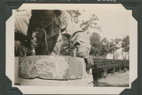 Man drinking from water fountain (ddr-densho-545-45)