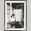 Woman sitting on a porch (ddr-densho-463-148)