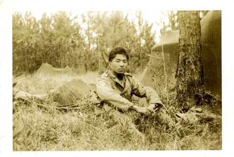 Soldier sitting near tents (ddr-densho-22-209)