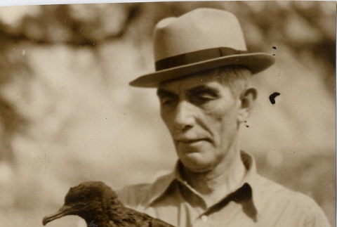 Honolulu ornithologist posing with a bird (ddr-njpa-2-603)