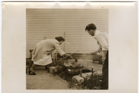 Man and woman grilling (ddr-densho-433-1106)