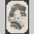 woman sitting on hood of card (ddr-densho-378-482)