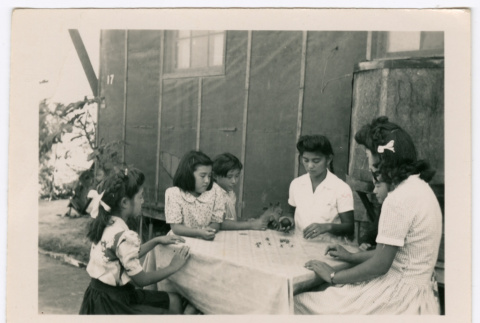 Six girls playing jacks on a table (ddr-densho-475-403)