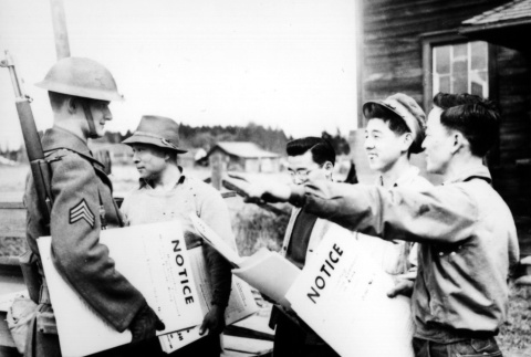Nisei helping to post exclusion orders (ddr-densho-34-46)