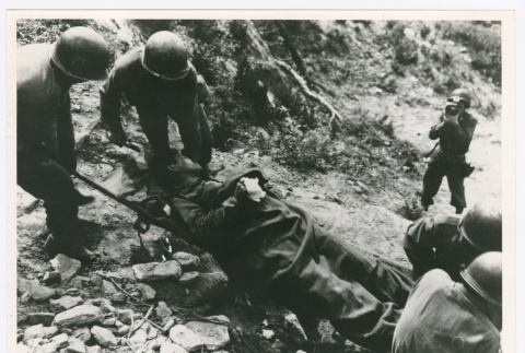 Servicepeople transporting soldier on stretcher (ddr-densho-1007-160)