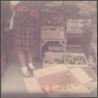 Woman standing by boxes of vegetables and fruits (ddr-densho-523-569)