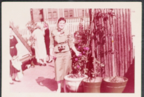 Woman with camera standing by plants (ddr-densho-534-104)
