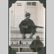 Man sitting on steps holding rifle (ddr-ajah-2-141)