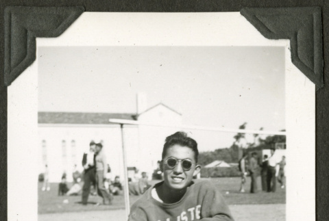 Young man sitting on ground in athletic gear (ddr-densho-475-595)
