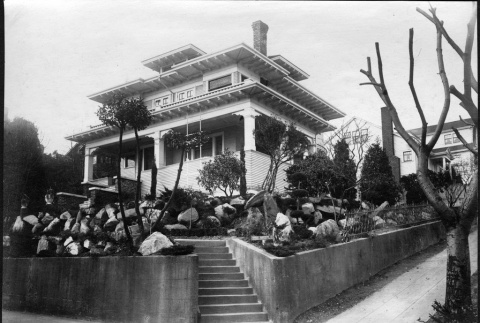 Landscape and rockery installation with a Kubota Gardening Company sign in the yard. (ddr-densho-354-107)