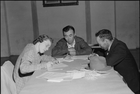 Government worker interviewing father and son (ddr-densho-151-217)