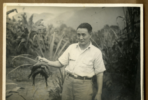 Japanese Peruvian man holding fish (ddr-csujad-33-196)