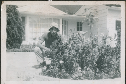 Man kneeling by flower bed (ddr-densho-293-50)