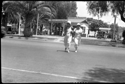 Two women crossing a street (ddr-densho-480-44)