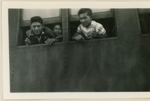 Young men leaning out a train car window (ddr-densho-37-917)