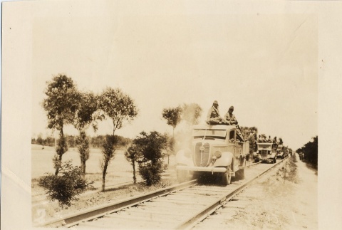 Soldiers riding in trucks on train tracks (ddr-njpa-6-85)
