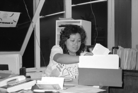 Woman sorting through papers (ddr-densho-1007-562)