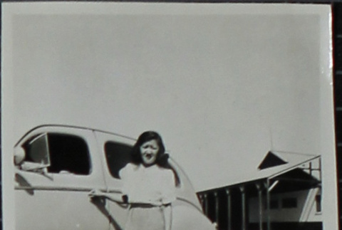 A woman standing next to a car (ddr-densho-321-1234)
