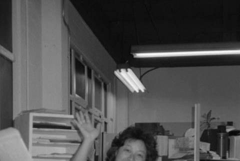 Woman waving at desk (ddr-densho-1007-561)