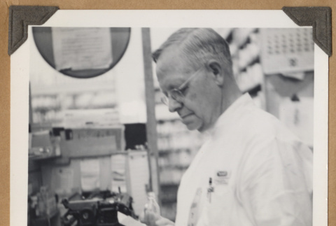 Pharmacy worker at The Owl Drug Co. (ddr-densho-542-100)