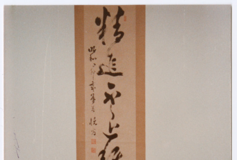 Man sitting in front of Japanese scroll hanging (ddr-densho-501-50)