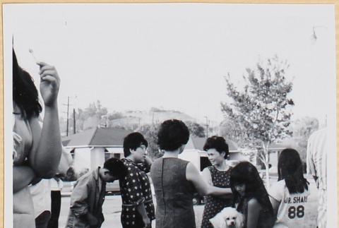 Group standing in driveway, girl holding dog (ddr-densho-522-92)