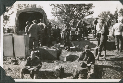 Men sitting and standing around truck, eating (ddr-ajah-2-188)