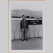 William Shiomi by Tour Exit sign (ddr-densho-522-580)