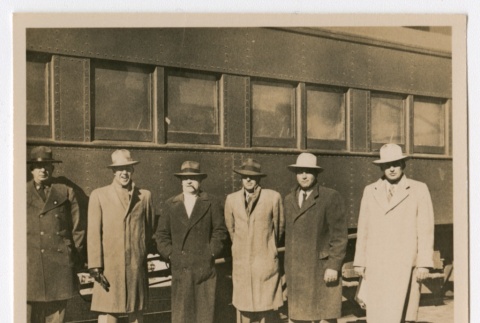 Six men posing in front of a train (ddr-densho-223-7)