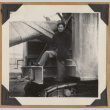 Man posing on large piece of equipment (ddr-densho-542-137)