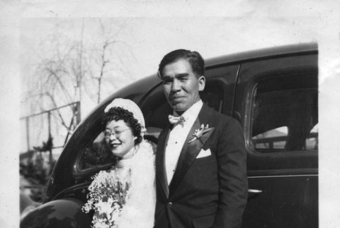 Matao and Shigeko Koga standing by car after their wedding (ddr-ajah-6-170)