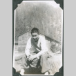Man sitting with barracks in background (ddr-ajah-2-340)