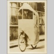 A man riding a bicycle with a rain cover (ddr-njpa-13-1348)