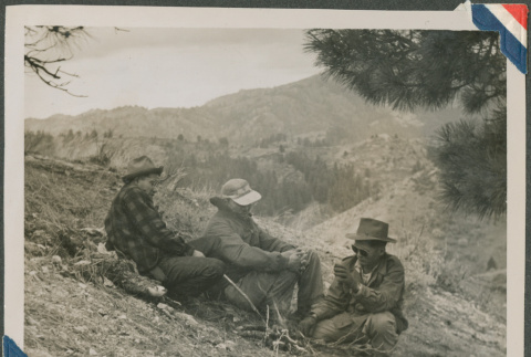 Three men sitting around a fire (ddr-densho-201-940)