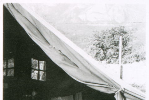 Man in chair in front of tent (ddr-densho-1007-854)